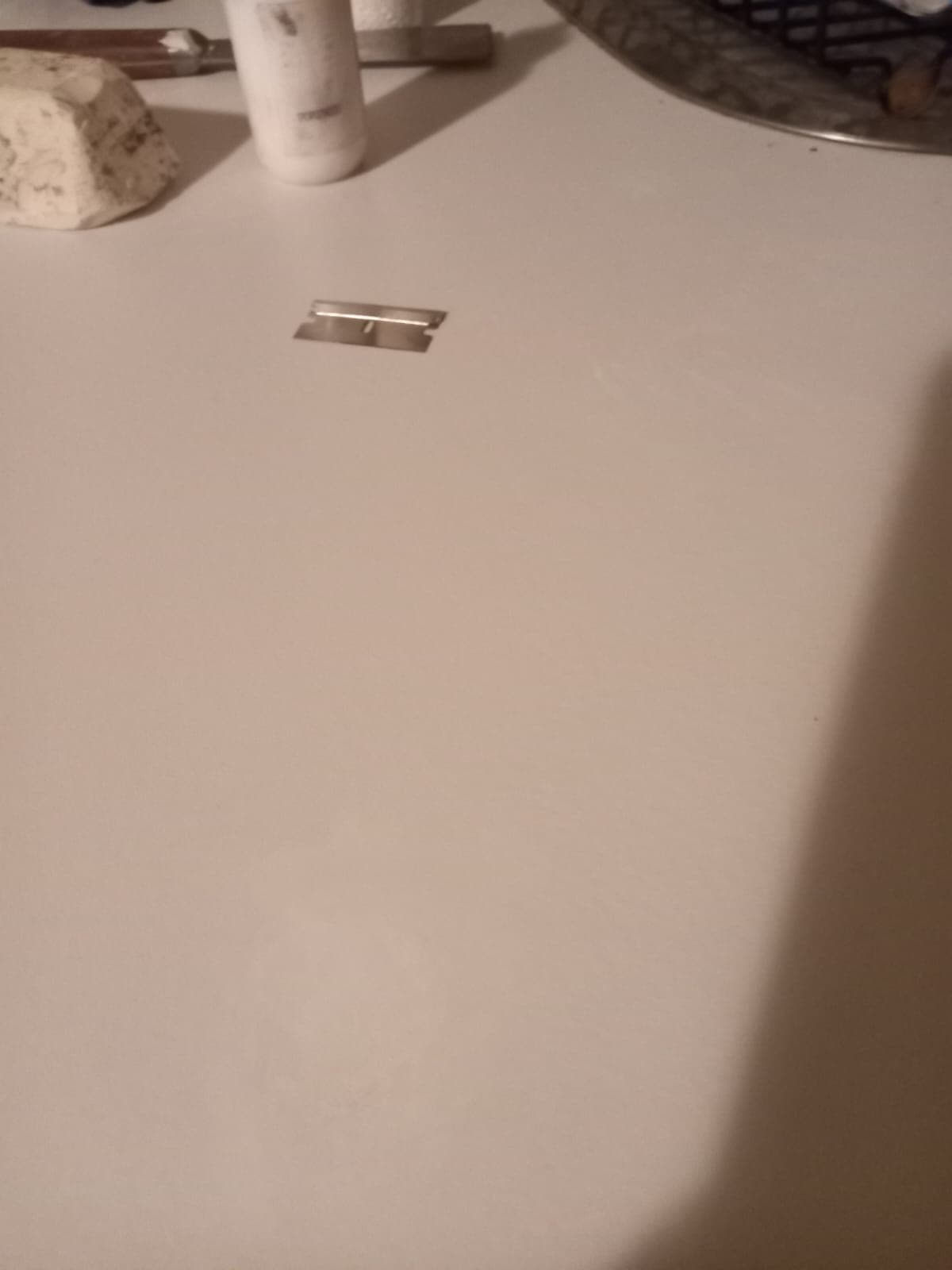 After: the same white stone benchtop with the burn mark removed and the surface polished clean.