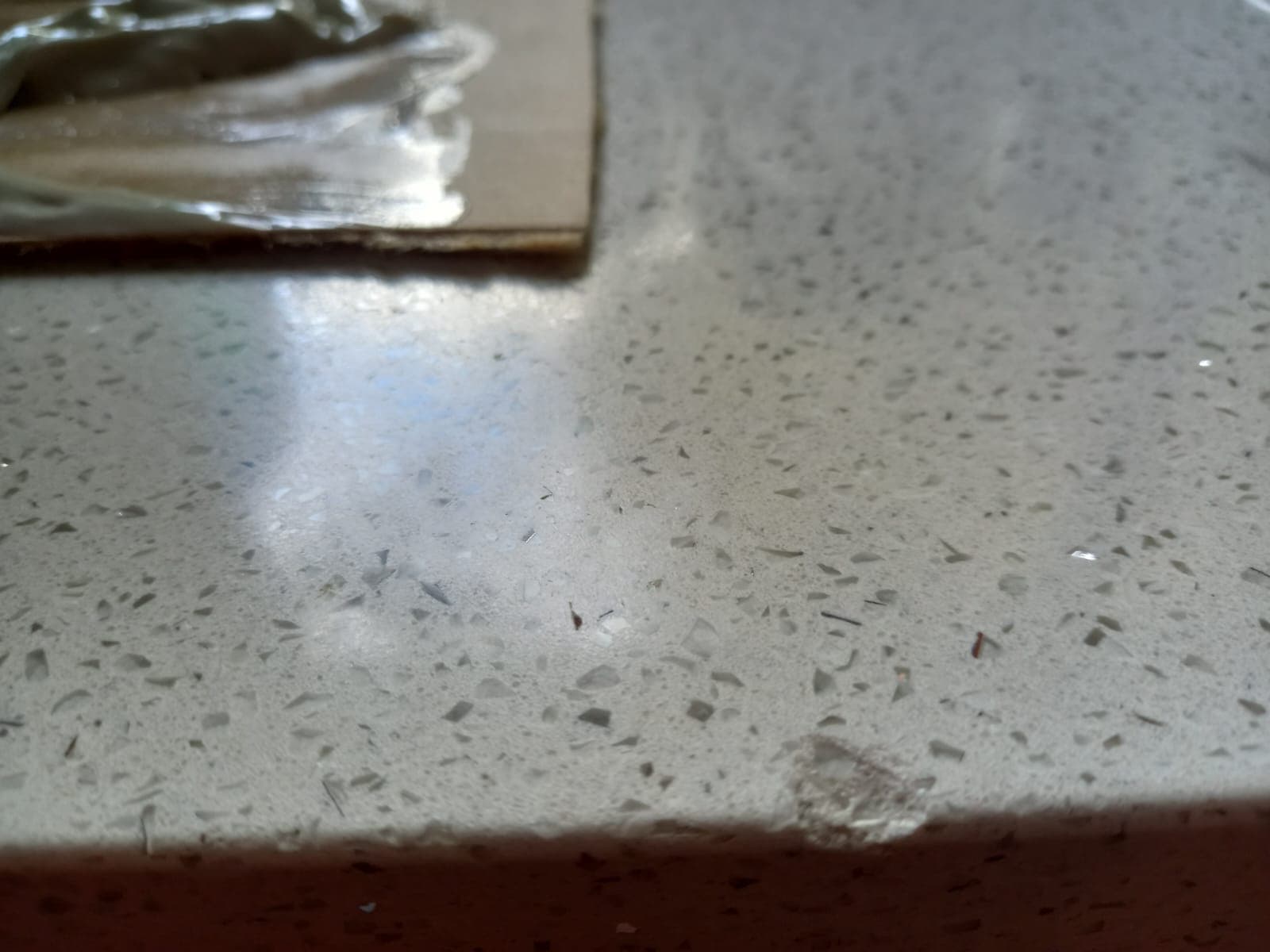 Before: a chip in the surface of a white engineered stone benchtop.