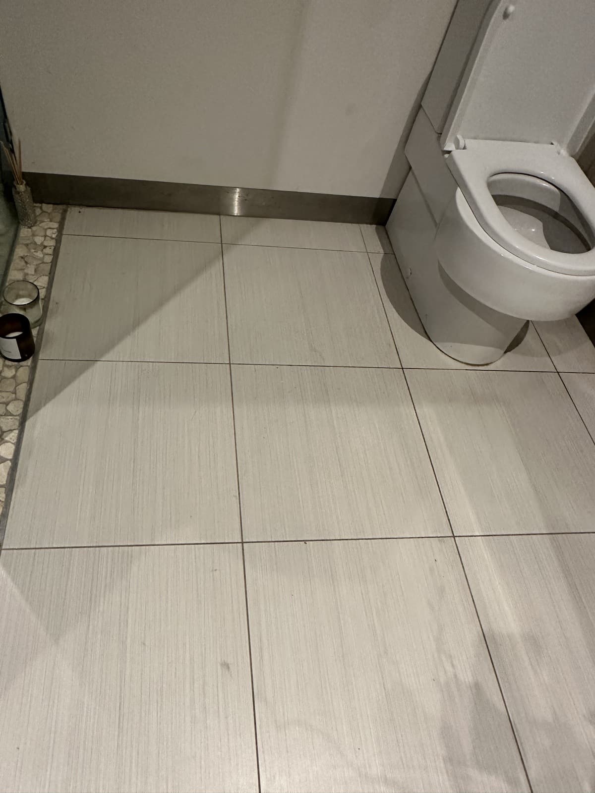 After: the bathroom floor tile repaired and blended with the surrounding tiles.